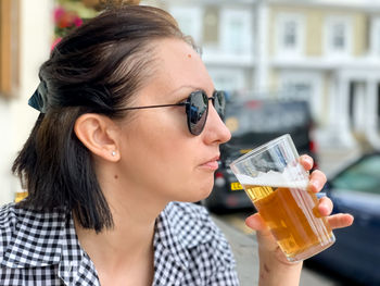 Young woman drinking beer in cafe or restaurant pub outdoor. drinking alcohol  lager or ale candid. 