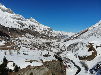 Scenic view of snowcapped mountains against clear blue sky