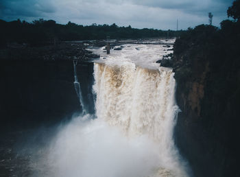 Scenic view of waterfall against sky