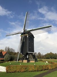 Traditional windmill on field against sky