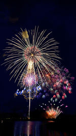 Low angle view of firework display against sky at night