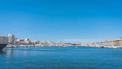 City by sea against clear blue sky