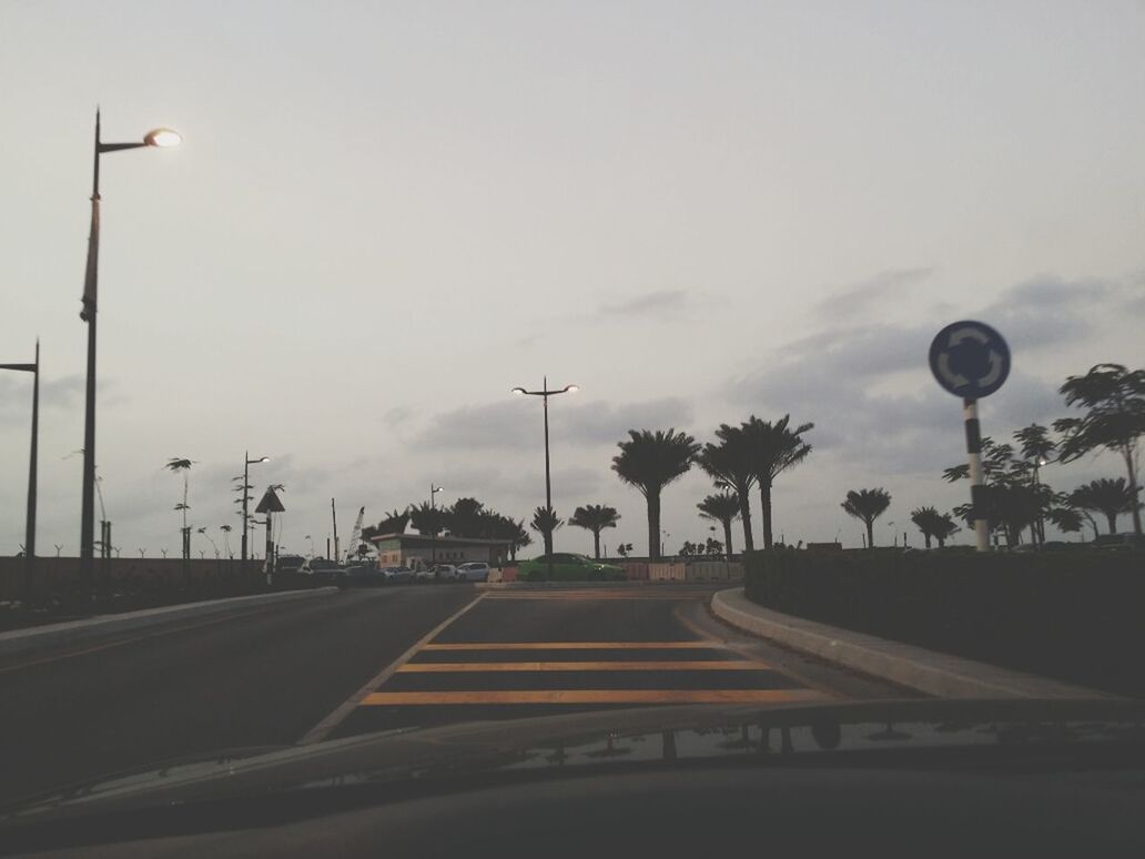 transportation, road, the way forward, street light, road marking, sky, street, car, tree, diminishing perspective, land vehicle, cloud - sky, road sign, mode of transport, vanishing point, empty, lighting equipment, asphalt, cloud, outdoors