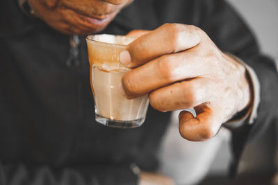 Midsection of man holding coffee cup