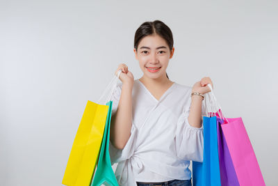 Portrait of smiling young woman against white background