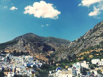 Aerial view of townscape and mountains against sky