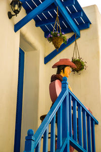 Low angle view of woman standing on staircase against building