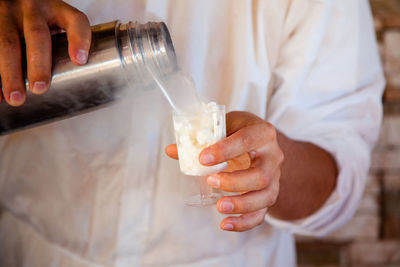 Midsection of person preparing food in glass