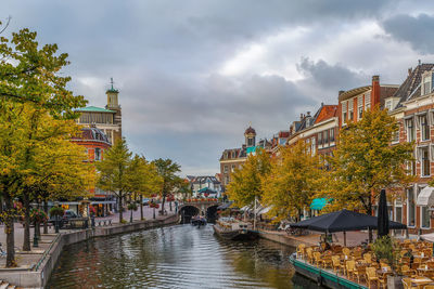 Canal amidst buildings in city during rainy season