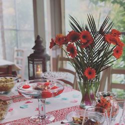 Flower vase on table against glass wall