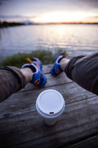 Low section of man with coffee beans against sky