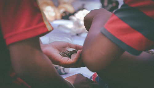 Cropped image of boys holding coins