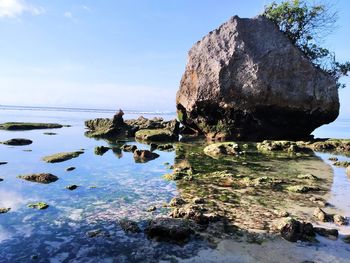 Rock formation on beach against sky