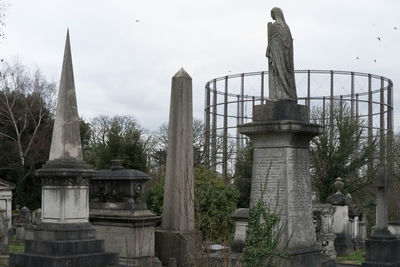 Sculpture in cemetery against sky