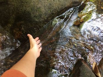 Low section of person on rock by river