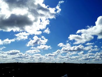 Low angle view of silhouette trees against sky