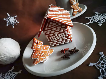 Gingerbread house and christmas tree decorated with white glaze in new year patterns 