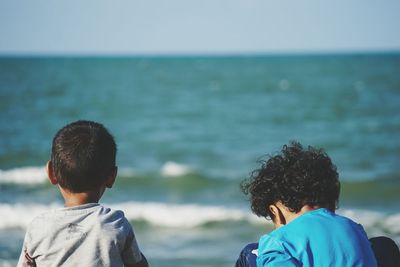 Rear view of siblings at beach