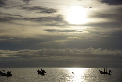 Boats in sea at sunset