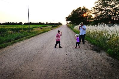 Father clicking photograph of children playing on street