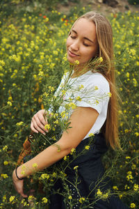 Young woman smiling while standing on field