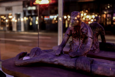 Statue of man sitting at night