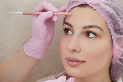 Close-up of young woman holding dentures