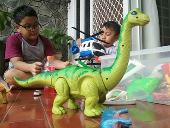 Full length of boy sitting at toy