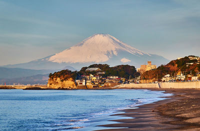 Scenic view of sea against sky and snowcapped mountain