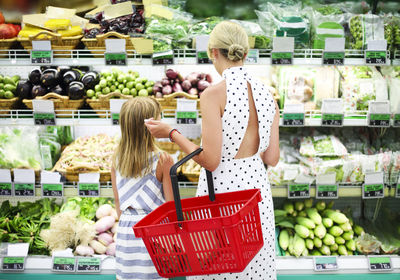 Mother holding strawberry in supermarket