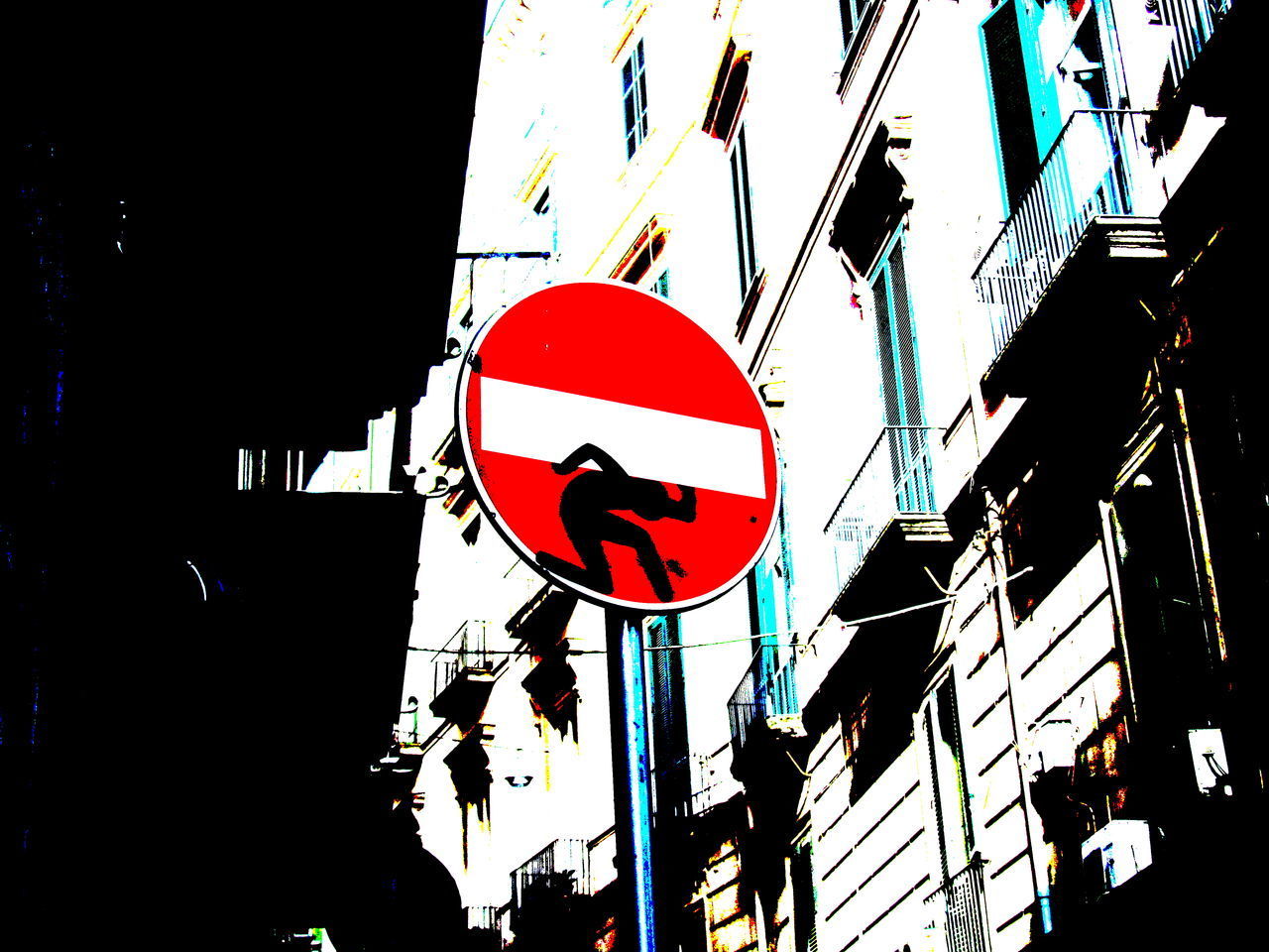 LOW ANGLE VIEW OF ROAD SIGN AGAINST CITY