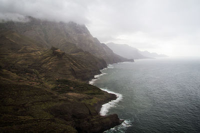 Scenic view of sea and mountains against sky