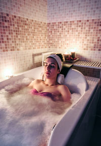 Woman lying in bathtub