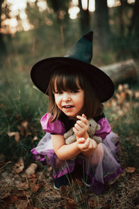 Portrait of happy girl holding purple on field