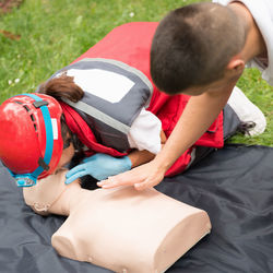 Healthcare workers practicing on cpr dummy at park