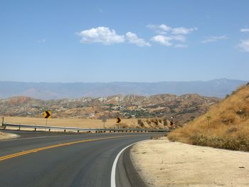 Road by mountain against sky