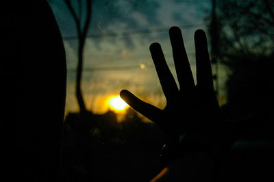 Close-up of silhouette hand against sky