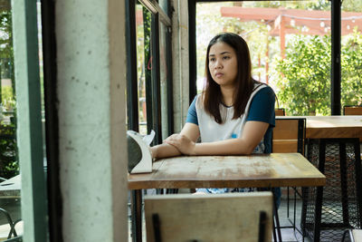 Depressed woman sitting at table in cafe