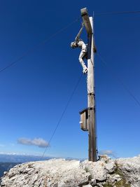 Low angle view of telephone pole against clear blue sky