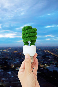 Close-up of woman holding ice cream against sky