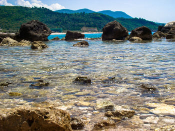 Scenic view of rocks in sea against sky