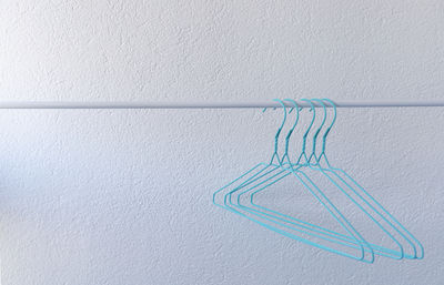 Turquoise hangers on a rail on a white background, clothes, wardrobe organization