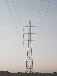 Low angle view of silhouette electricity pylon against sky