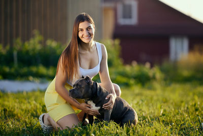 Portrait of young woman sitting on grassy field