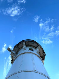 Low angle view of lighthouse by building against sky