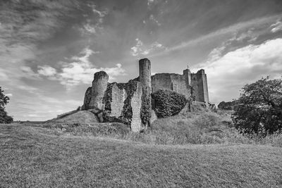 Old ruins on field against sky