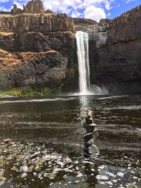 Scenic view of waterfall against sky