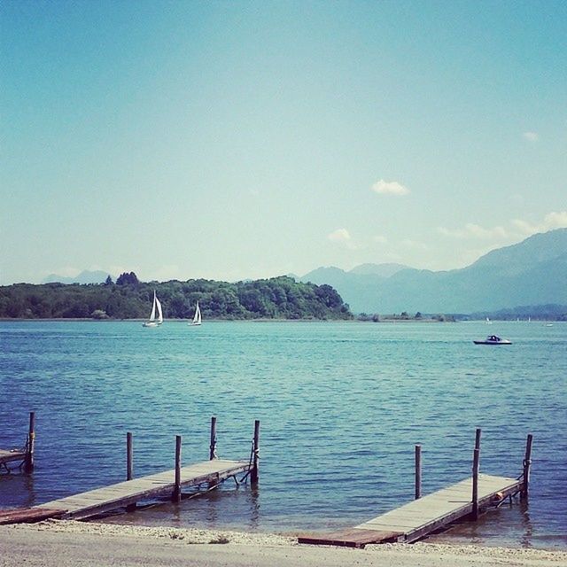 water, nautical vessel, mountain, transportation, boat, sea, tranquil scene, tranquility, mode of transport, scenics, blue, beauty in nature, nature, mountain range, moored, sky, copy space, clear sky, idyllic, lake