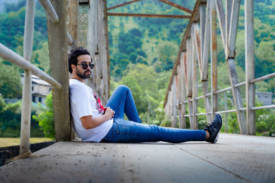 Side view of young man sitting outdoors