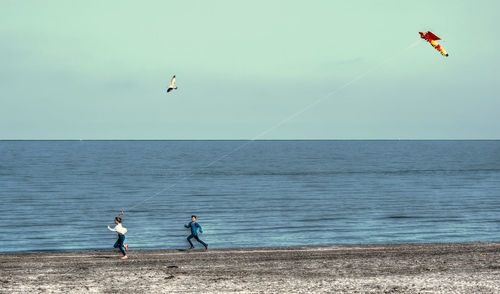 People on sea against sky